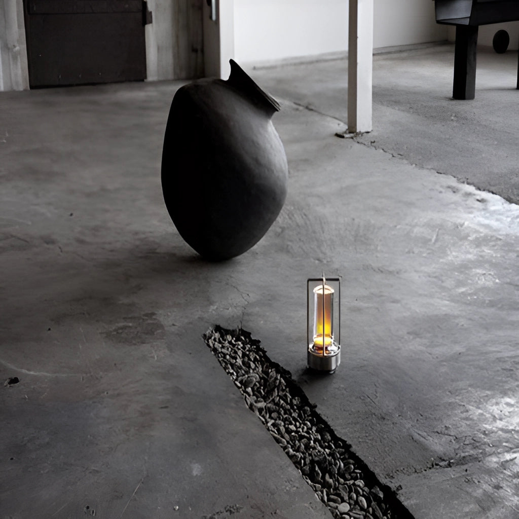 Black and grey table lamp with dimming feature, placed on a wooden floor.