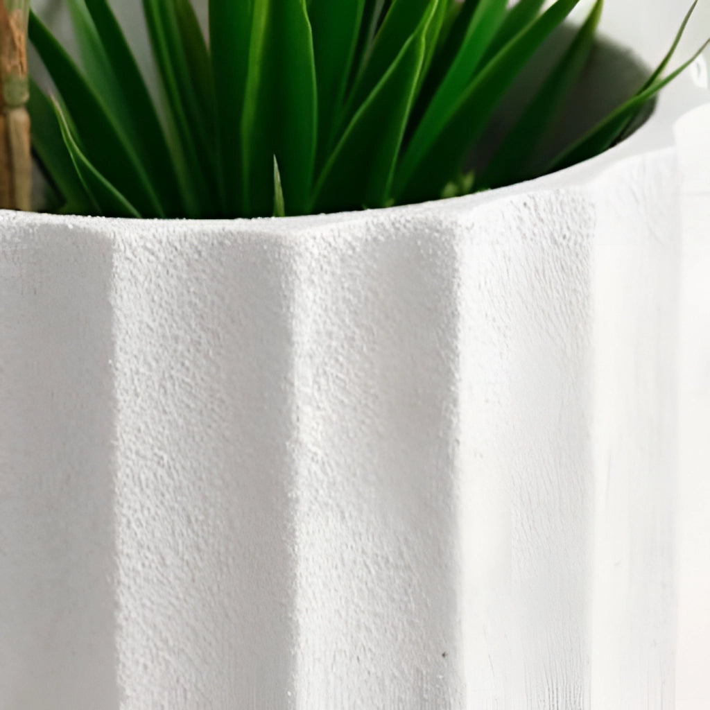 Textured Ceramic Polygon Vase with Geometric Design holding a green terrestrial plant with long stems and leaves.