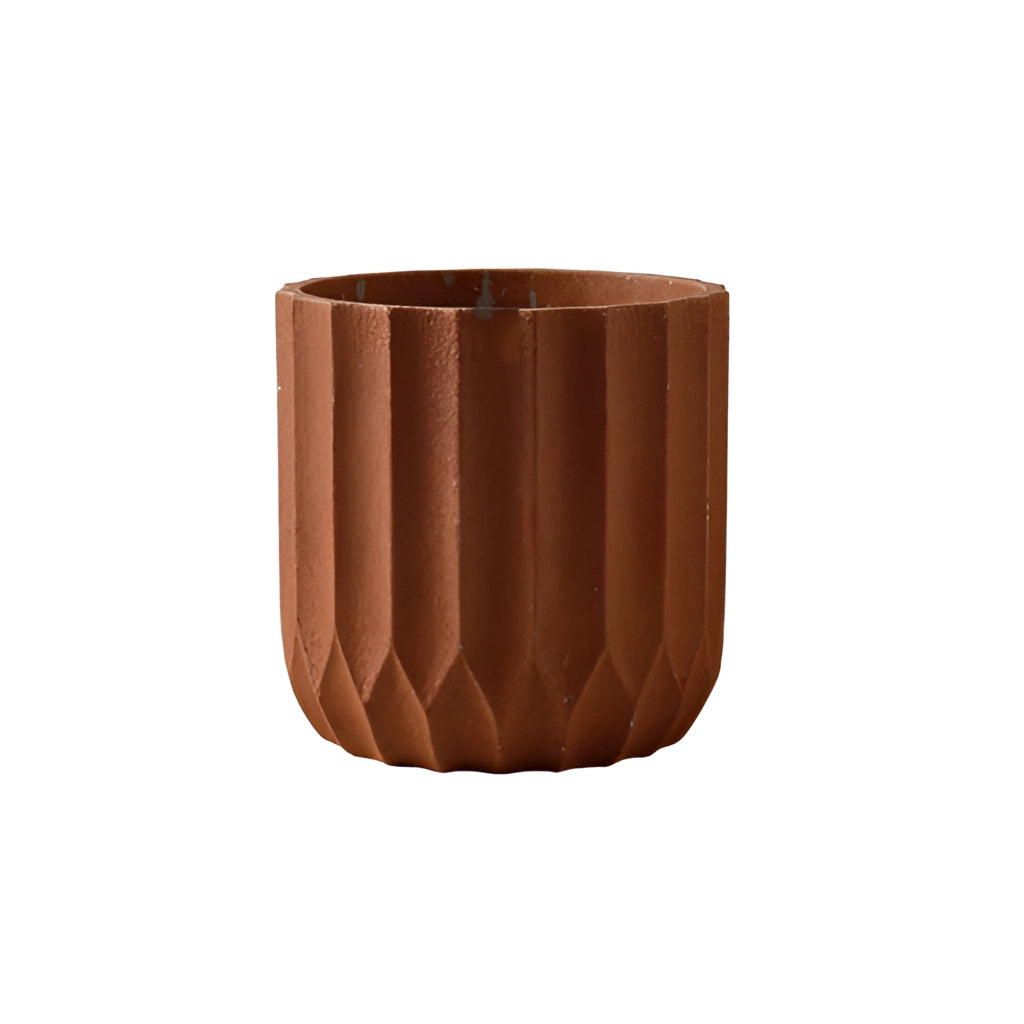 A large brown textured ceramic polygon vase with a geometric design placed on a wooden surface.