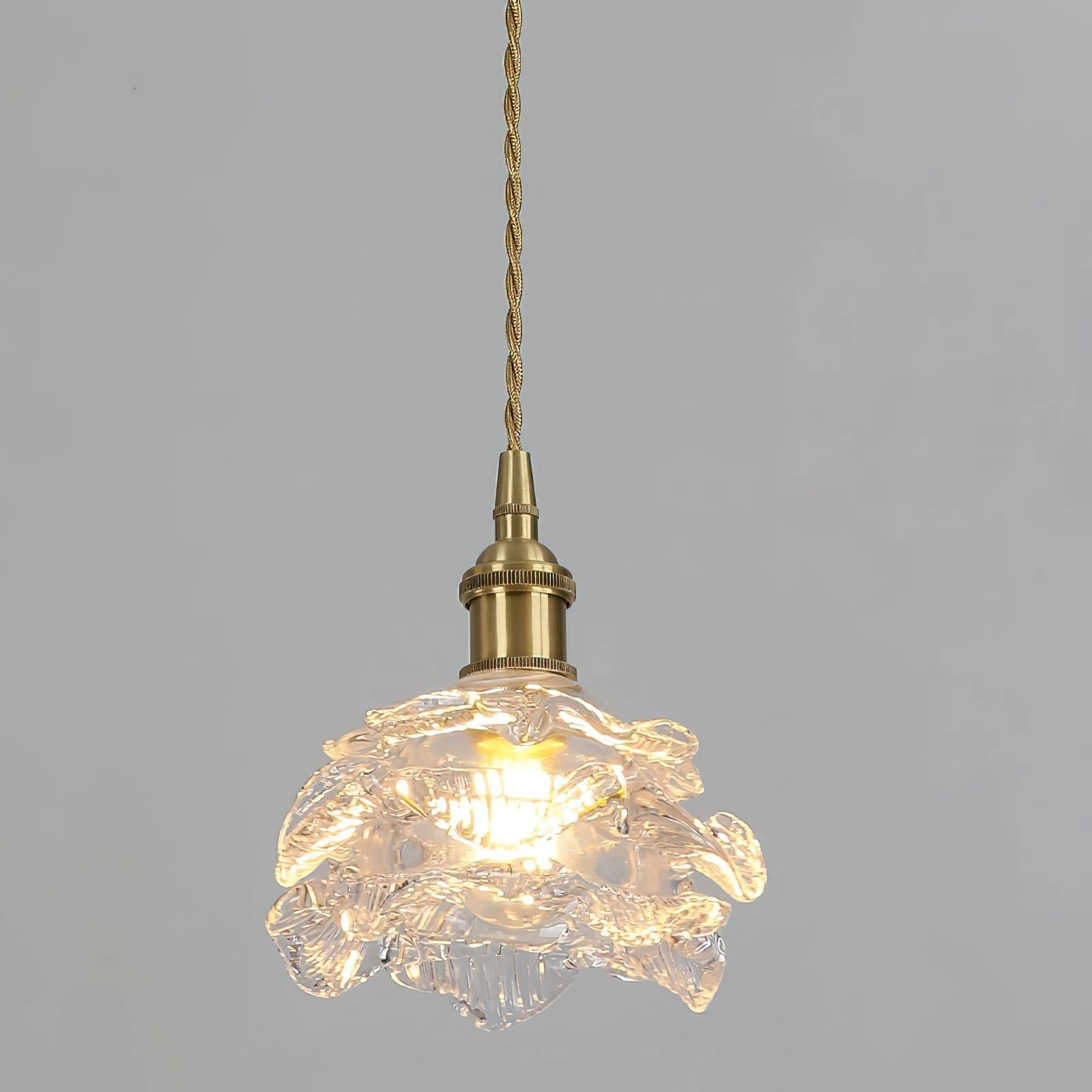 Vintage brass wall light with rose glass shade, elegant wall sconce with amber tones and intricate ornament design, featuring a circular metal fixture.