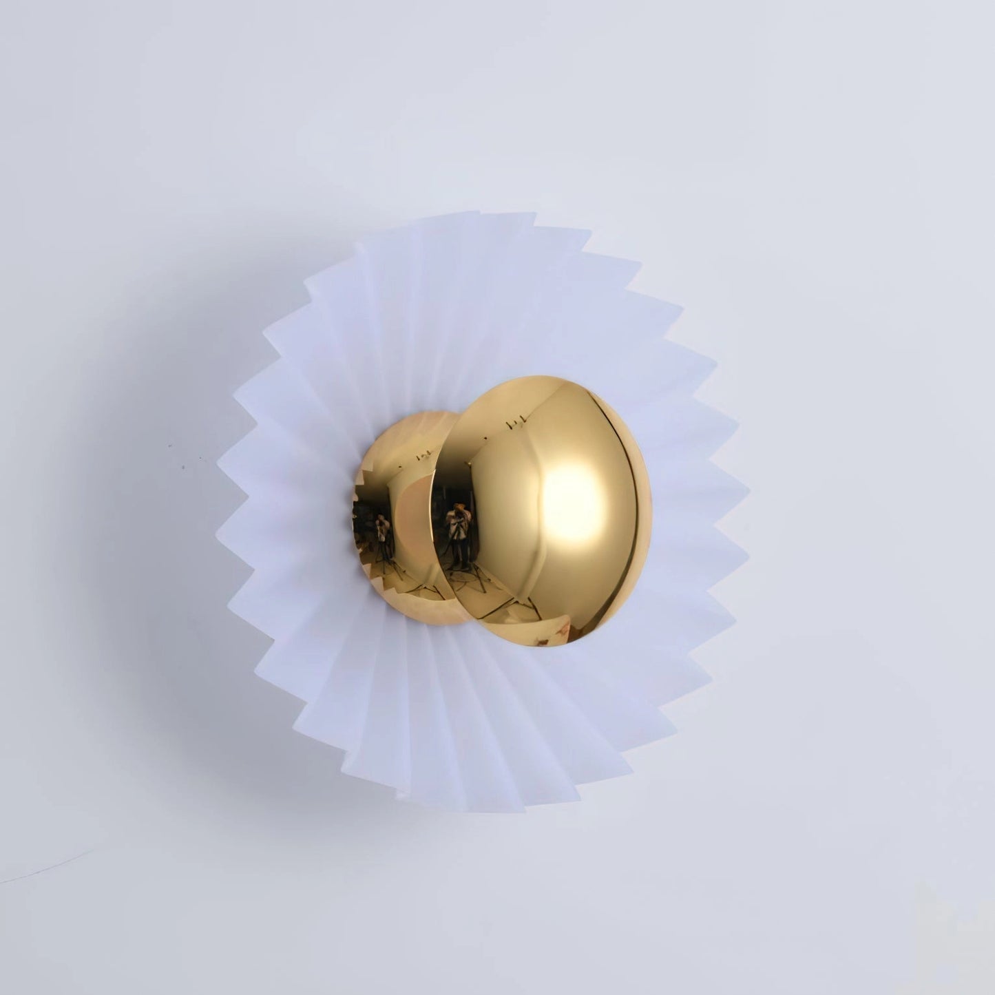 Modern wall lamp with artistic elegance featuring a circular wood and metal design, incorporating brass elements.