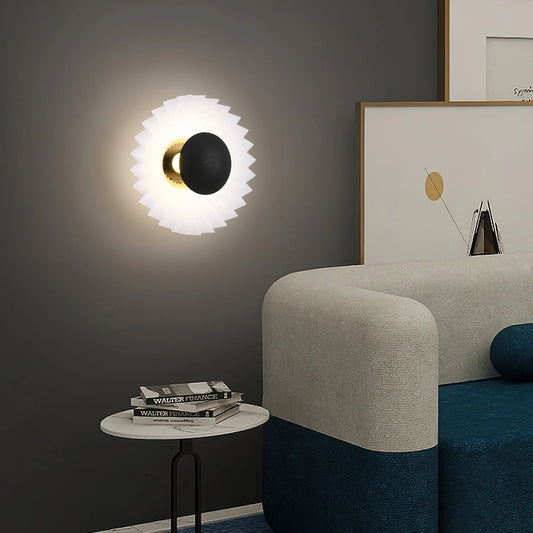 Modern wall lamp with artistic elegance, featuring premium materials. The lamp is mounted on a grey wooden panel, illuminating a stylish interior with a couch and table.