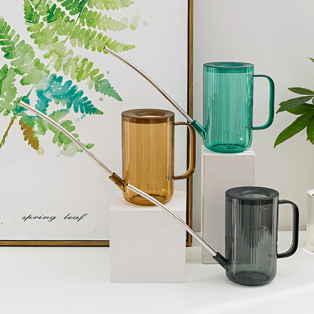 A sleek watering can with an extended spout, designed for accurate water delivery, placed near potted plants and wooden decor.