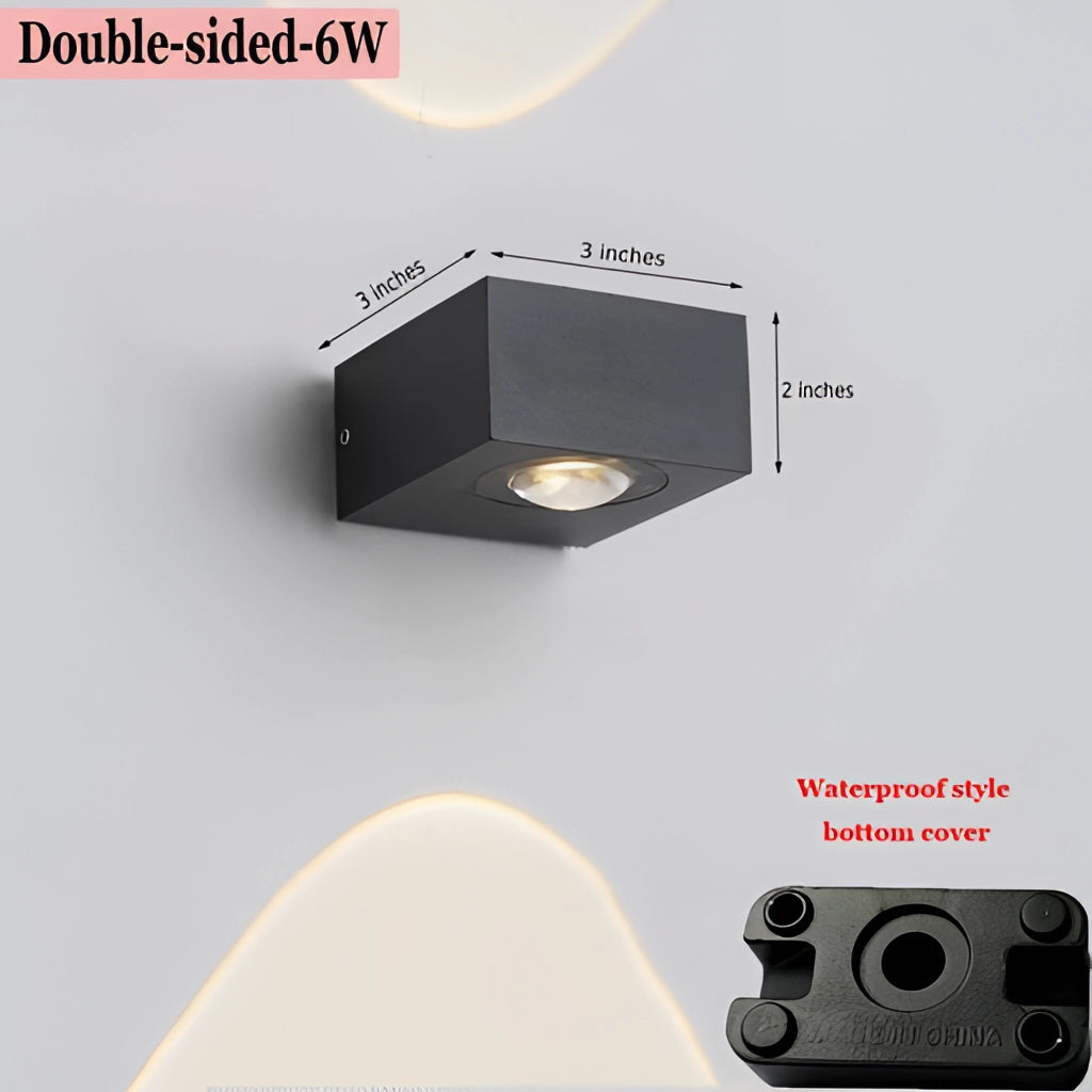 Double-sided waterproof black UFO wall light with a sleek circular design mounted on a wooden surface.