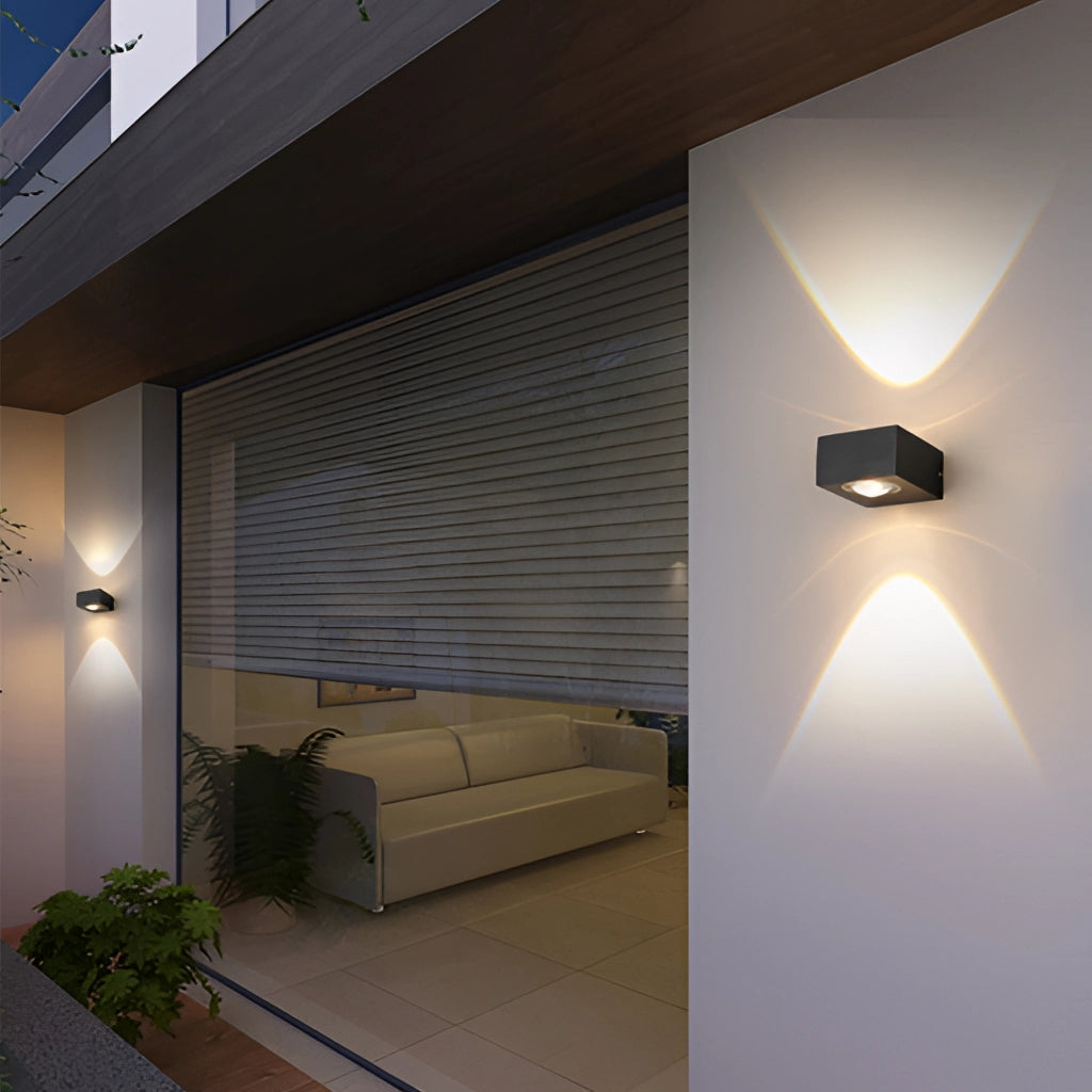Waterproof black UFO wall light mounted on a wooden wall, illuminating a modern interior space with grey flooring and a couch nearby.