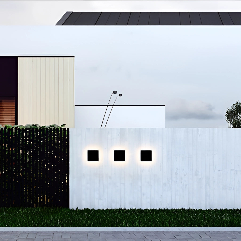 Waterproof LED outdoor wall lamp aluminum light fixture mounted on a modern building facade with a rectangular window, surrounded by trees and plants.