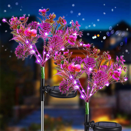 Waterproof Solar Phalaenopsis LED Flower Lights with purple and pink flowers illuminated on decorative branches against a clear sky.