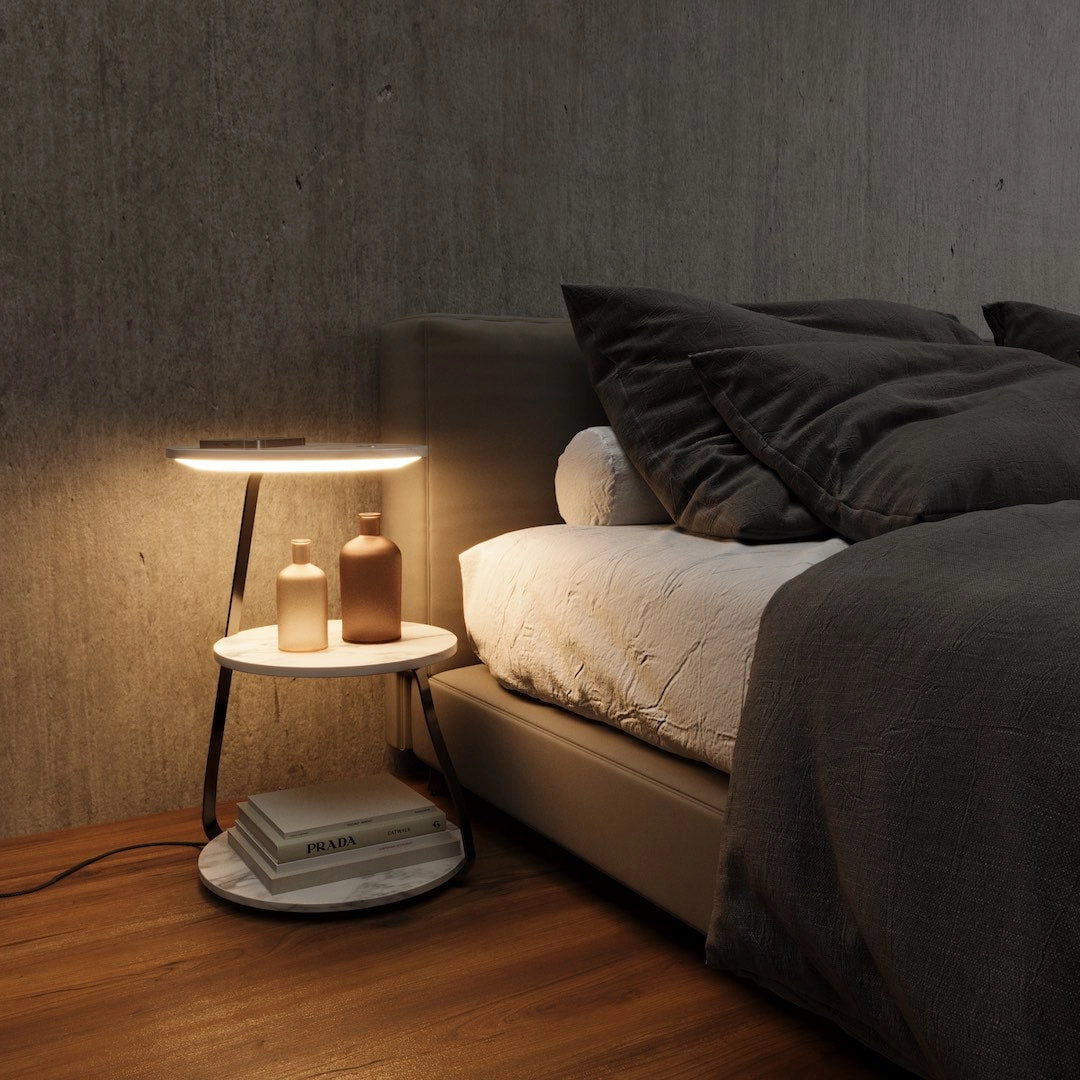 A premium wooden desk with wireless charging capabilities, featuring a comfortable design, situated in a modern, well-lit room with hardwood flooring and a stylish lamp.