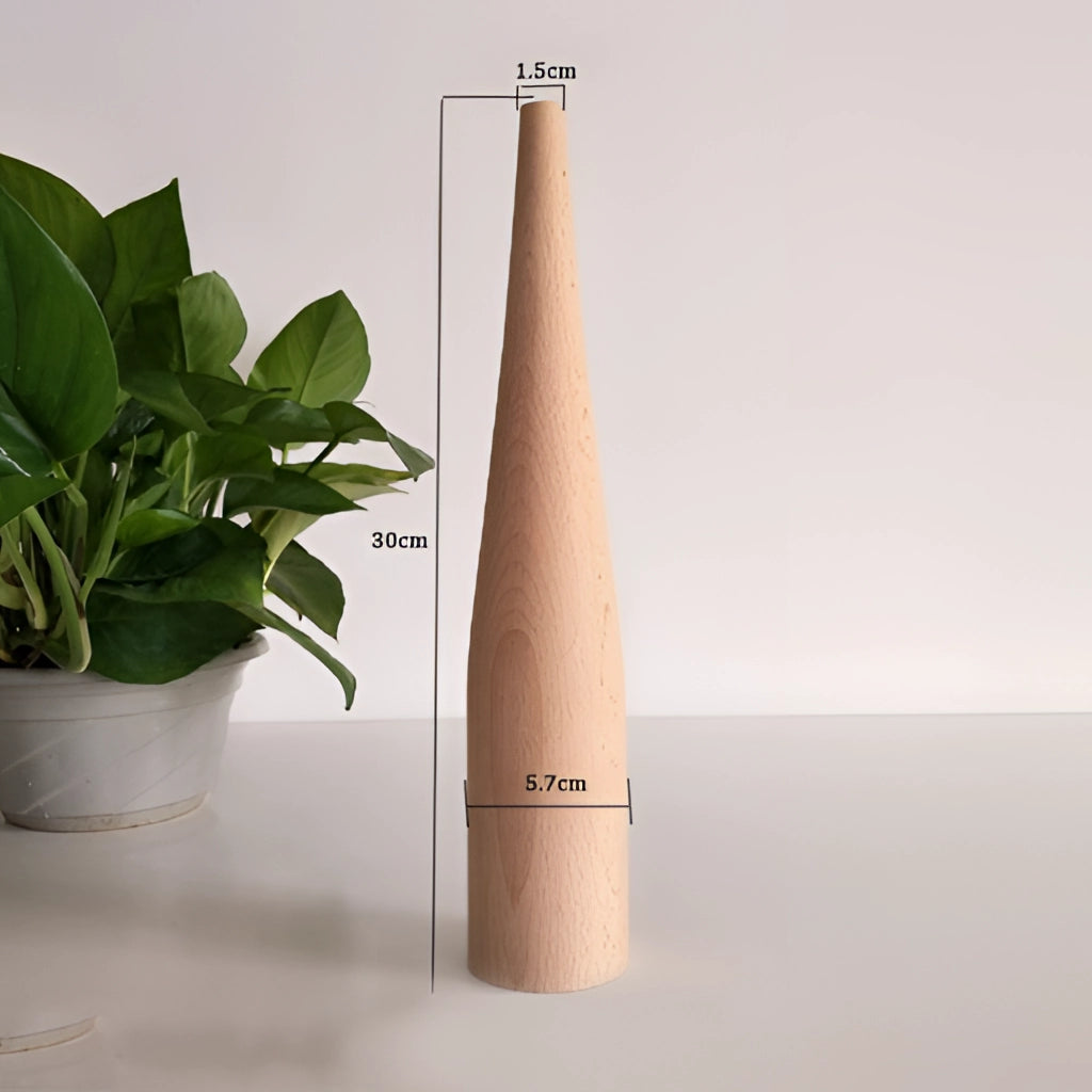 A tall wooden decor vase holding a lush houseplant, placed on an office desk with various supplies, including a pen and notebook.
